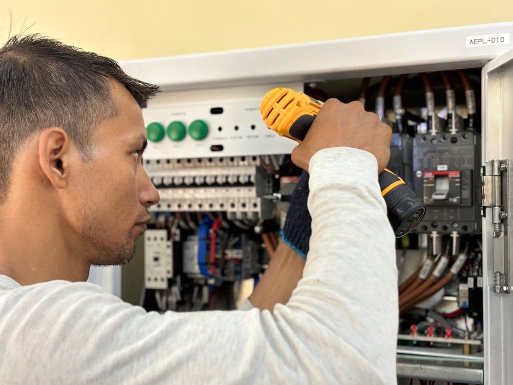 Électricien professionnel intervenant sur une installation électrique