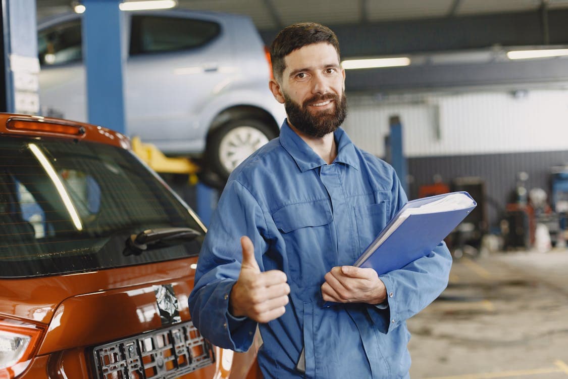 Mécanicien automobile en train de travailler sur un véhicule dans son garage