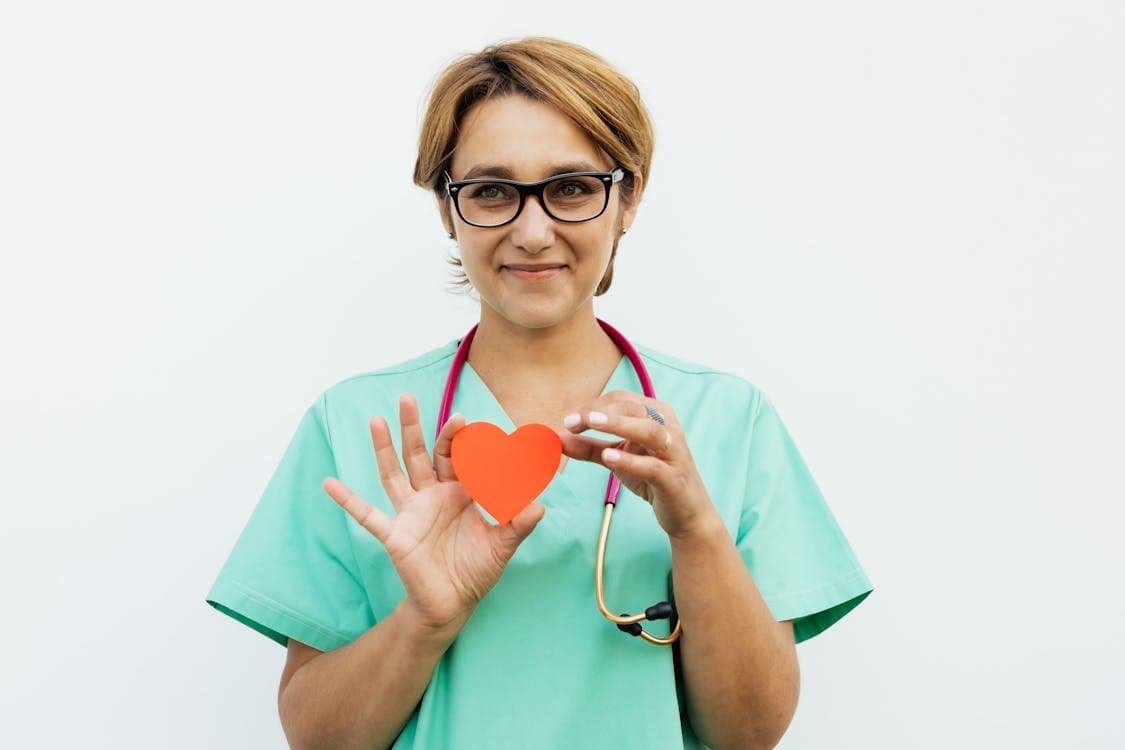 Médecin femme souriante avec stéthoscope en consultation médicale