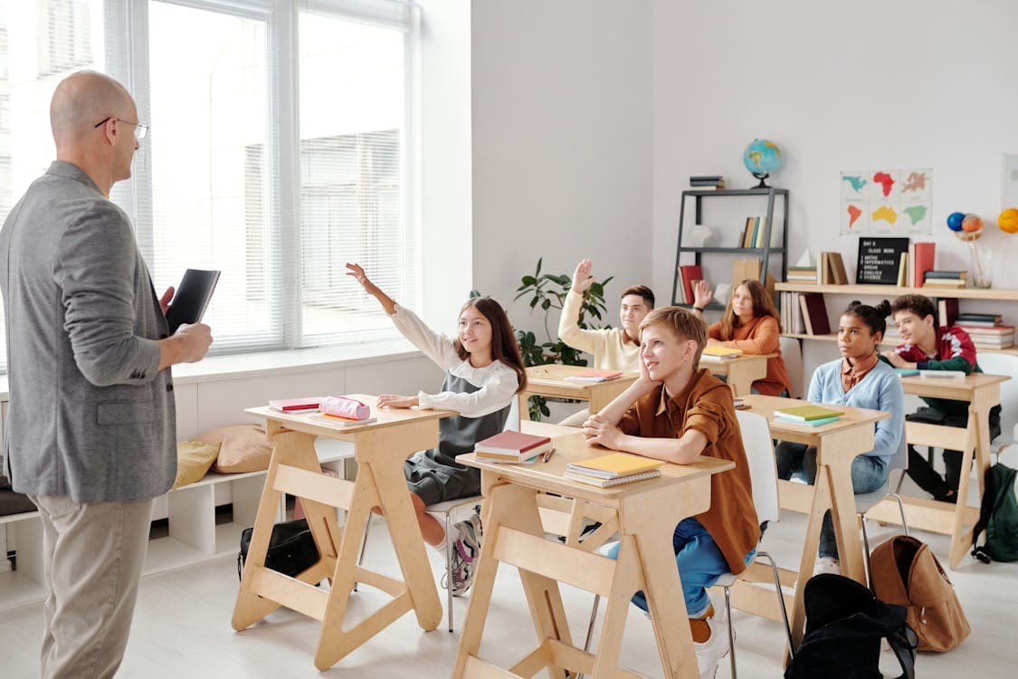 Enseignant souriant animant un cours au tableau blanc